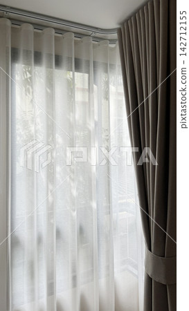 Luxury beige ripple fold curtains with white sheer on a curved track and sunlight Luxury beige ripple fold curtains with white sheer on a curved track and sunlight 142712155