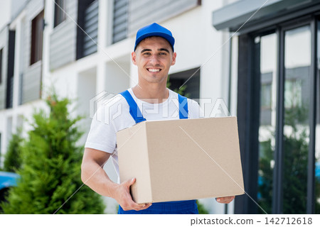 Young delivery man hold a cardboard box in his hands 142712618