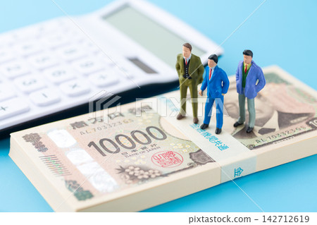 一疊100萬日圓鈔票和一個穿著西裝的商人模特兒。 142712619
