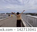 A woman crossing a bridge in Kisarazu; her back to the camera as she returns from clam digging. 142713041