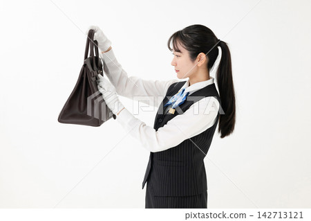 一位女士正在評估一個包 一位女士正在評估一個包 142713121