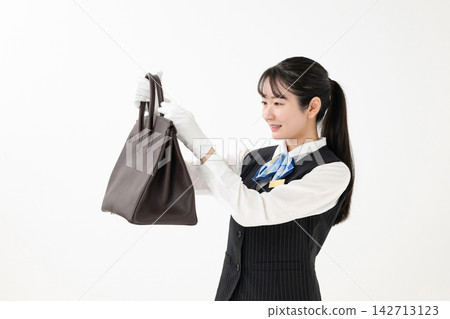 一位女士正在評估一個包 一位女士正在評估一個包 142713123