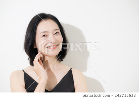 A beauty portrait of a woman in her 50s, striking with her beautiful skin and natural expression, smiling directly at the camera. (Skincare) A beauty portrait of a woman in her 50s, striking with her beautiful skin and natural expression, smiling directly at the camera. (Skincare) 142713638
