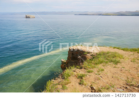 Lake Baikal in summer. The view from Cape Uyuga near the village of Kurma over the bay and the islands. Lake Baikal in summer. The view from Cape Uyuga near the village of Kurma over the bay and the islands. 142713730