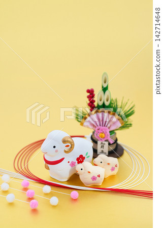 羊年新年賀卡設計:金色背景上,一隻母白羊和小白羊,配有門松(新年松枝裝飾)和水引(裝飾繩)。 羊年新年賀卡設計:金色背景上,一隻母白羊和小白羊,配有門松(新年松枝裝飾)和水引(裝飾繩)。 142714648