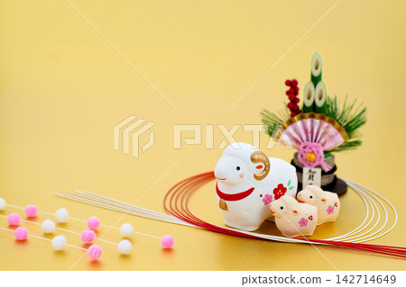 New Year's greeting card design for the Year of the Sheep: A mother and baby white sheep with kadomatsu (New Year's pine decoration) and mizuhiki (decorative cord) on a gold background. 142714649