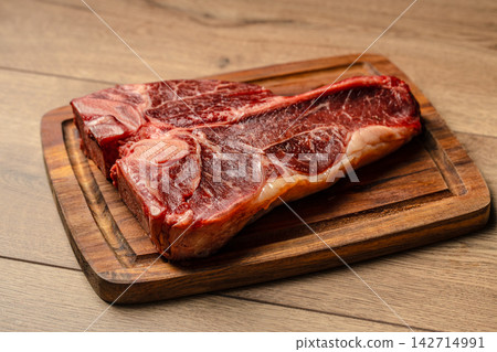 Raw T Bone Steak on Rustic Wooden Board Raw T Bone Steak on Rustic Wooden Board 142714991