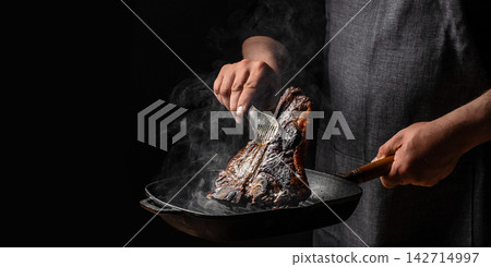 Chef Lifting Grilled T Bone Steak from Smoking Pan Chef Lifting Grilled T Bone Steak from Smoking Pan 142714997