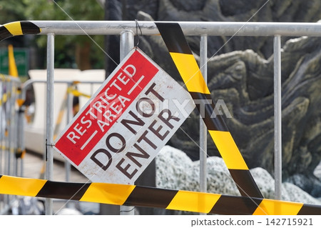 A warning sign in English reads "RESTRICTED AREA DO NOT ENTER" - No Entry. A warning sign in English reads "RESTRICTED AREA DO NOT ENTER" - No Entry. 142715921