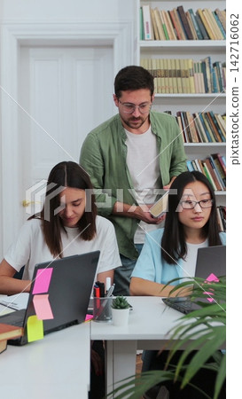 Happy multi ethnic college students smiling look at camera, posing in modern university library. Education, study, modern tech concept. Happy multi ethnic college students smiling look at camera, posing in modern university library. Education, study, modern tech concept. 142716062