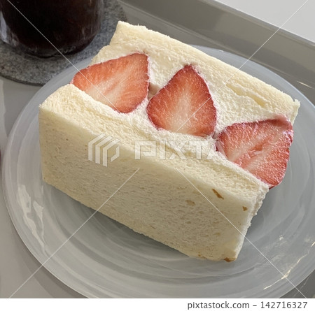 Soft strawberry sando filled with fluffy whipped cream and juicy strawberries. Light, sweet, and refreshing, offering a clean and charming dessert perfect for modern cafe visuals. Soft strawberry sando filled with fluffy whipped cream and juicy strawberries. Light, sweet, and refreshing, offering a clean and charming dessert perfect for modern cafe visuals. 142716327