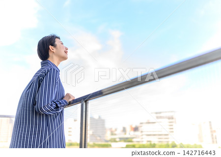 一位女子仰望藍天，感受到自由與希望。 142716443