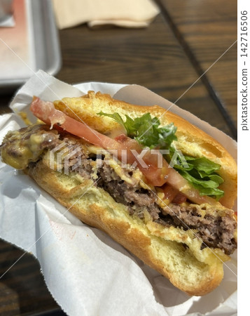 A mouthwatering burger with a juicy patty, fresh lettuce, tomato, and melted cheese, all nestled in a soft bun. Perfect for food photography, showcasing the indulgence of classic comfort food. A mouthwatering burger with a juicy patty, fresh lettuce, tomato, and melted cheese, all nestled in a soft bun. Perfect for food photography, showcasing the indulgence of classic comfort food. 142716506