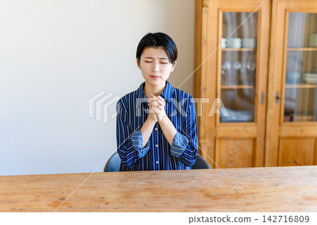 一名女子雙手合十祈禱。 一名女子雙手合十祈禱。 142716809