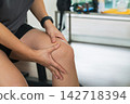 Woman holding painful knee after workout at gym 142718394