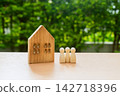 House and wooden figures on a table, family concept and protection and insurance. 142718396