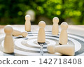 Wooden statue on a dartboard, a leadership concept representing the achievement of goals. 142718408