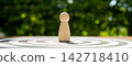 Wooden statue on a dartboard, a leadership concept representing the achievement of goals. 142718410