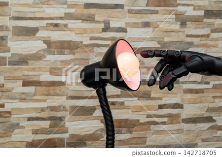 Robot or Prosthesis Hand Touching Glowing Smart Bulb in Desk Lamp Robot or Prosthesis Hand Touching Glowing Smart Bulb in Desk Lamp 142718705