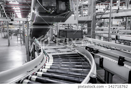 packing line in a logistics warehouse. conveyor belt in a modern production line packing line in a logistics warehouse. conveyor belt in a modern production line 142718762
