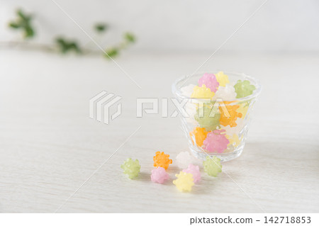 柔和的自然光籠罩著玻璃器皿和散落的糖果,呈現出一幅清新、以白色為底色的日式現代攝影作品。 柔和的自然光籠罩著玻璃器皿和散落的糖果,呈現出一幅清新、以白色為底色的日式現代攝影作品。 142718853