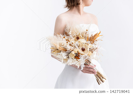 身穿婚紗的女子手捧一束花。 142719041