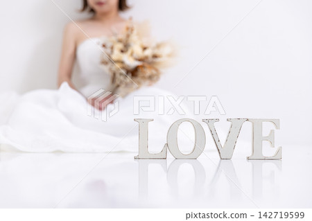 身穿婚紗的女子手捧一束花。 身穿婚紗的女子手捧一束花。 142719599