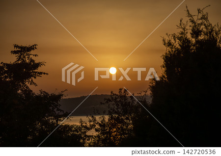 Wonderful sunset casting warm golden and orange hues over the charming village of Salvatierra de Tormes, Spain Wonderful sunset casting warm golden and orange hues over the charming village of Salvatierra de Tormes, Spain 142720536