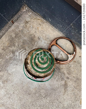 一塊蚊香和一個罐頭放在水泥地上。 一塊蚊香和一個罐頭放在水泥地上。 142720880