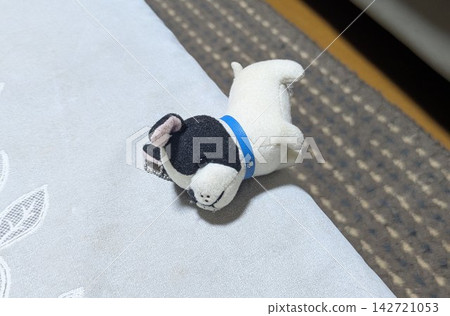 一隻滑稽的法國鬥牛犬毛絨玩具搖搖欲墜地立在桌子上,眼看就要掉下來了。 一隻滑稽的法國鬥牛犬毛絨玩具搖搖欲墜地立在桌子上,眼看就要掉下來了。 142721053