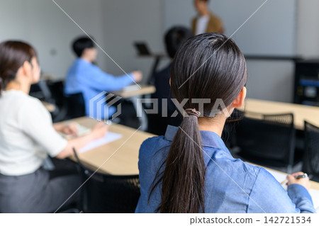 Female student taking notes during lecture Female student taking notes during lecture 142721534