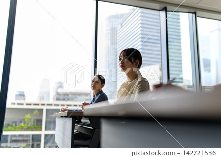 Lecture participants gazing at the view outside the window Lecture participants gazing at the view outside the window 142721536