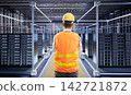 Programmer or engineer with computer notebook in data center 142721872