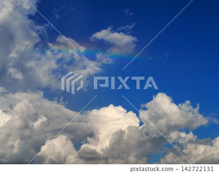 夏日藍天下，積雨雲上空橫跨一道彩虹。 142722131