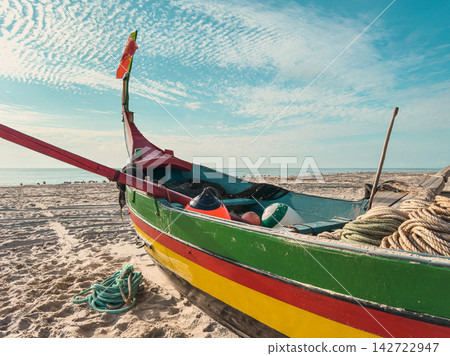 Traditional Arte Xavega fishing boat on sandy beach Traditional Arte Xavega fishing boat on sandy beach 142722947