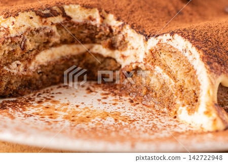 Delicious homemade tiramisu cake topped with cocoa Delicious homemade tiramisu cake topped with cocoa 142722948