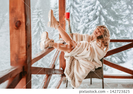 Laughing Woman Raising Coffee Mug on Snowy Terrace Laughing Woman Raising Coffee Mug on Snowy Terrace 142723825