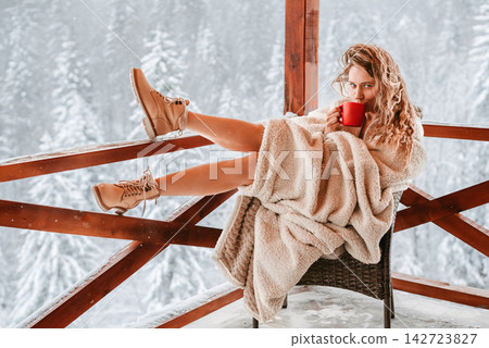 Woman in Blanket Drinking Coffee on Winter Terrace Woman in Blanket Drinking Coffee on Winter Terrace 142723827