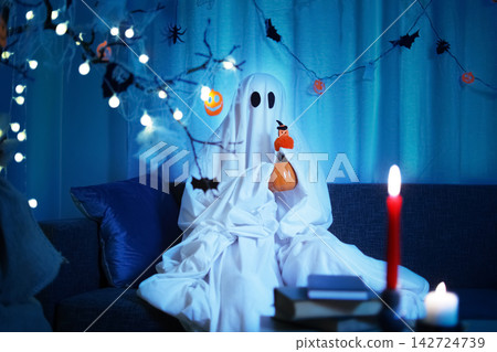 Enjoying a spooky evening in a ghost costume, embracing the playful atmosphere of a Halloween celebration, fun, entertainment, and tradition during Halloween night. Enjoying a spooky evening in a ghost costume, embracing the playful atmosphere of a Halloween celebration, fun, entertainment, and tradition during Halloween night. 142724739