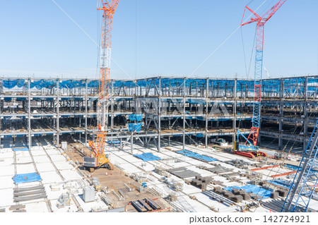 一個正在進行大型建築鋼結構施工的建築工地,以及一台履帶式起重機。 一個正在進行大型建築鋼結構施工的建築工地,以及一台履帶式起重機。 142724921