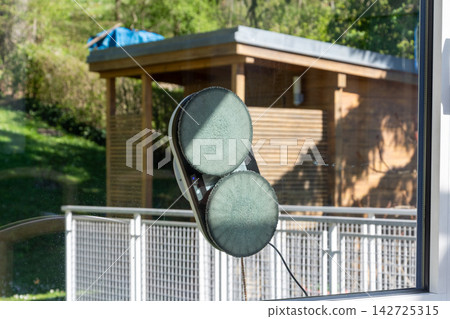 Window cleaning robot suctioning glass on a sunny outdoor facade Window cleaning robot suctioning glass on a sunny outdoor facade 142725315