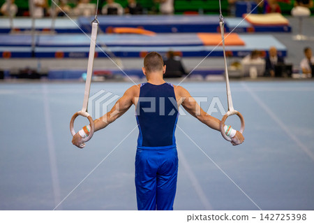 Gymnast exercise cross on rings Gymnast exercise cross on rings 142725398