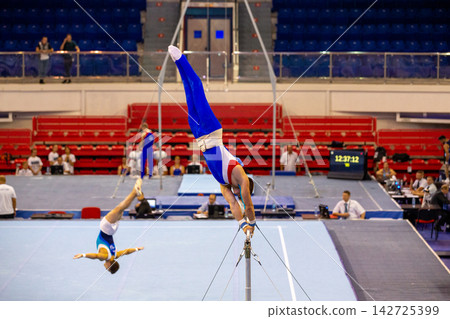 Gymnasts on horizontal bar and floor exercise Gymnasts on horizontal bar and floor exercise 142725399