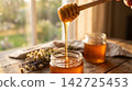 Pure organic liquid honey dripping smoothly and glowing under warm natural lighting. 142725453