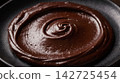 Luxurious melted cocoa texture displaying an elegant glossy swirl of dark chocolate ganache. 142725454
