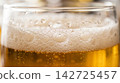 Extreme close up texture of a refreshing cold pint glass highlighting rising carbonation and amber liquid glow. 142725457