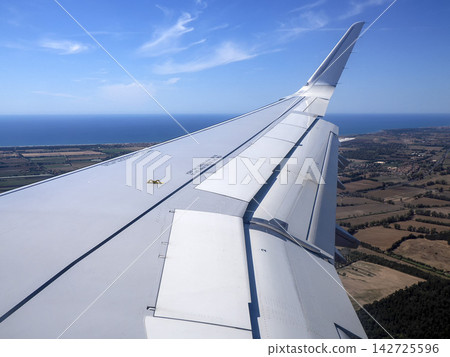 Airplane Wing With Extended Flaps During landing Roll Over Runway At Airport Airplane Wing With Extended Flaps During landing Roll Over Runway At Airport 142725596