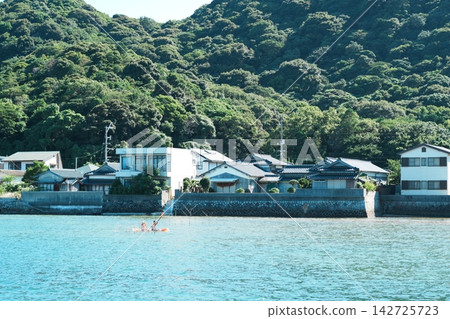 沿海一帶,碧綠的海水邊,聚集一排排瓦頂房屋。 沿海一帶,碧綠的海水邊,聚集一排排瓦頂房屋。 142725723