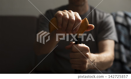 Middle age caucasian man hands holds cane closeup 142725857