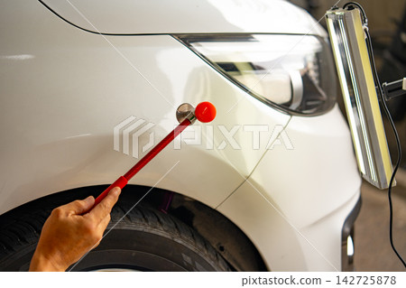 Removing dents on the car. PDR technology. Car body repair without painting. 142725878